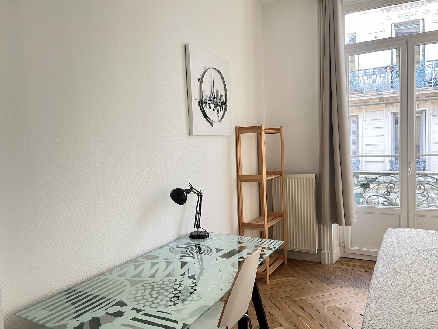 Bureau de chambre avec lampe noire, étagère en bois et lit près de la fenêtre